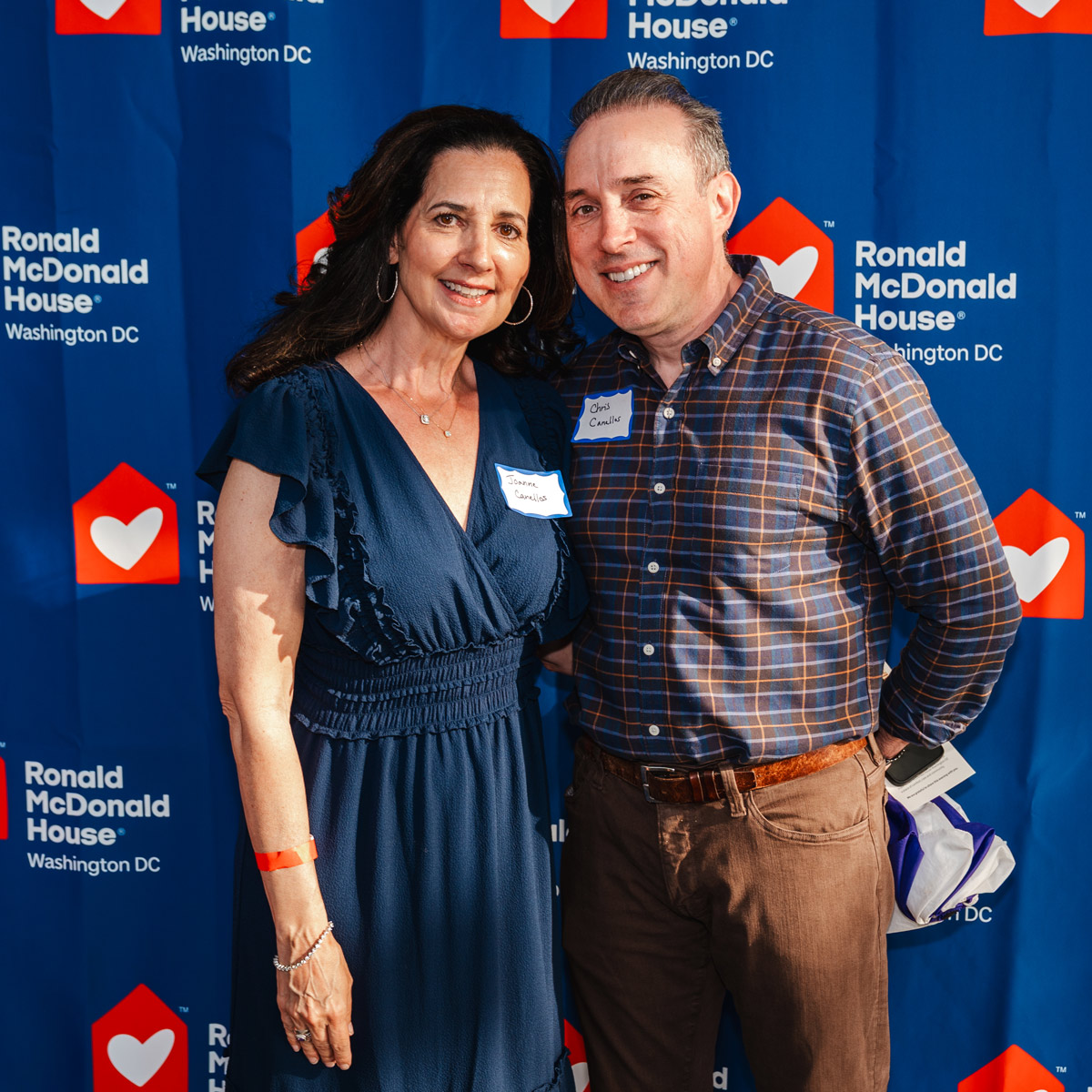 Joanne Canellos, Director of CJ's Pediatric Promise Fund, and Chris Canellos pose together in front of a Ronald McDonald House Washington DC event backdrop during the Audrey's Children film screening and anniversary celebration.