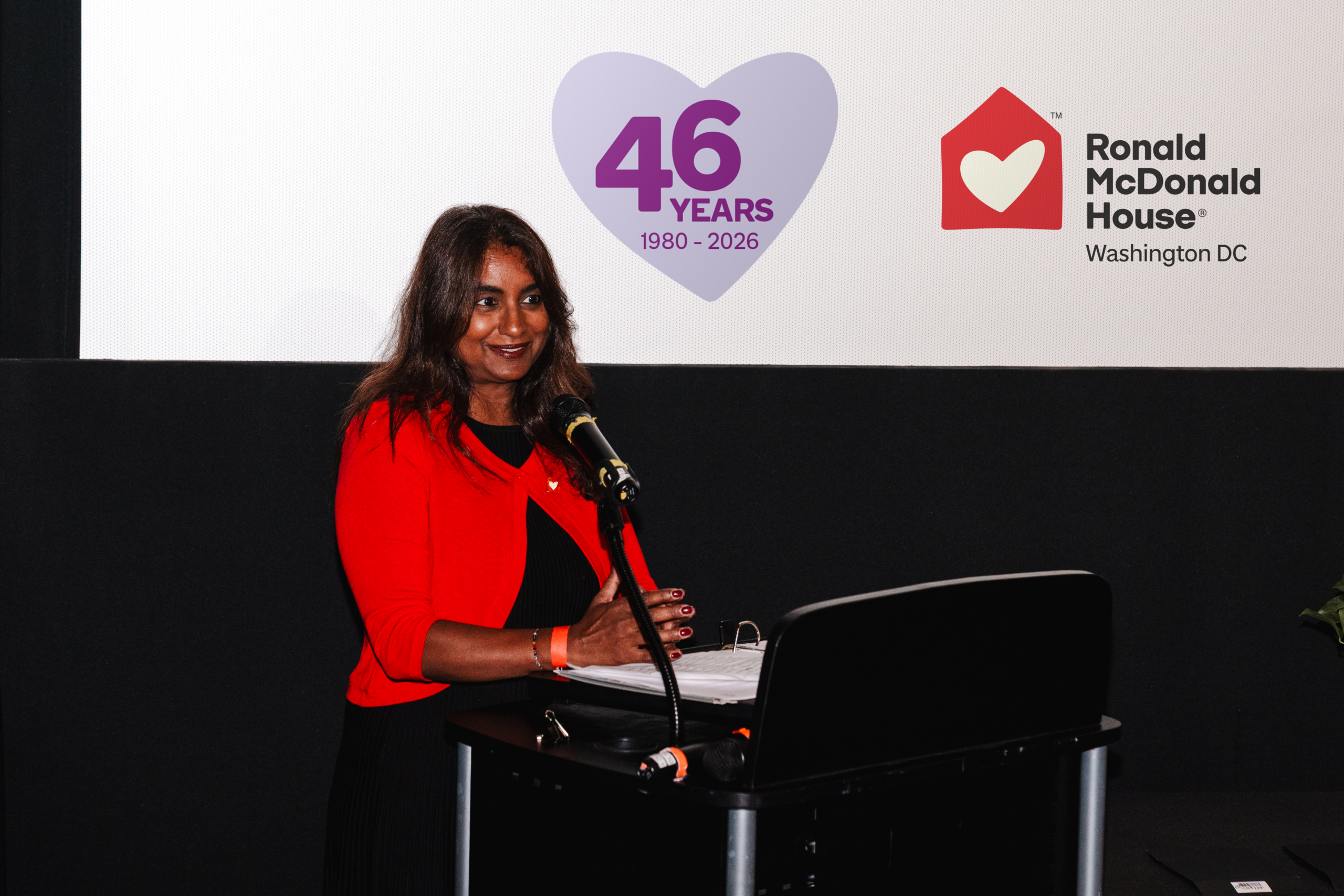 Board Chair Meera Pillai welcomes guests and reflects on the impact made possible through 46 years of community support, generosity and care.