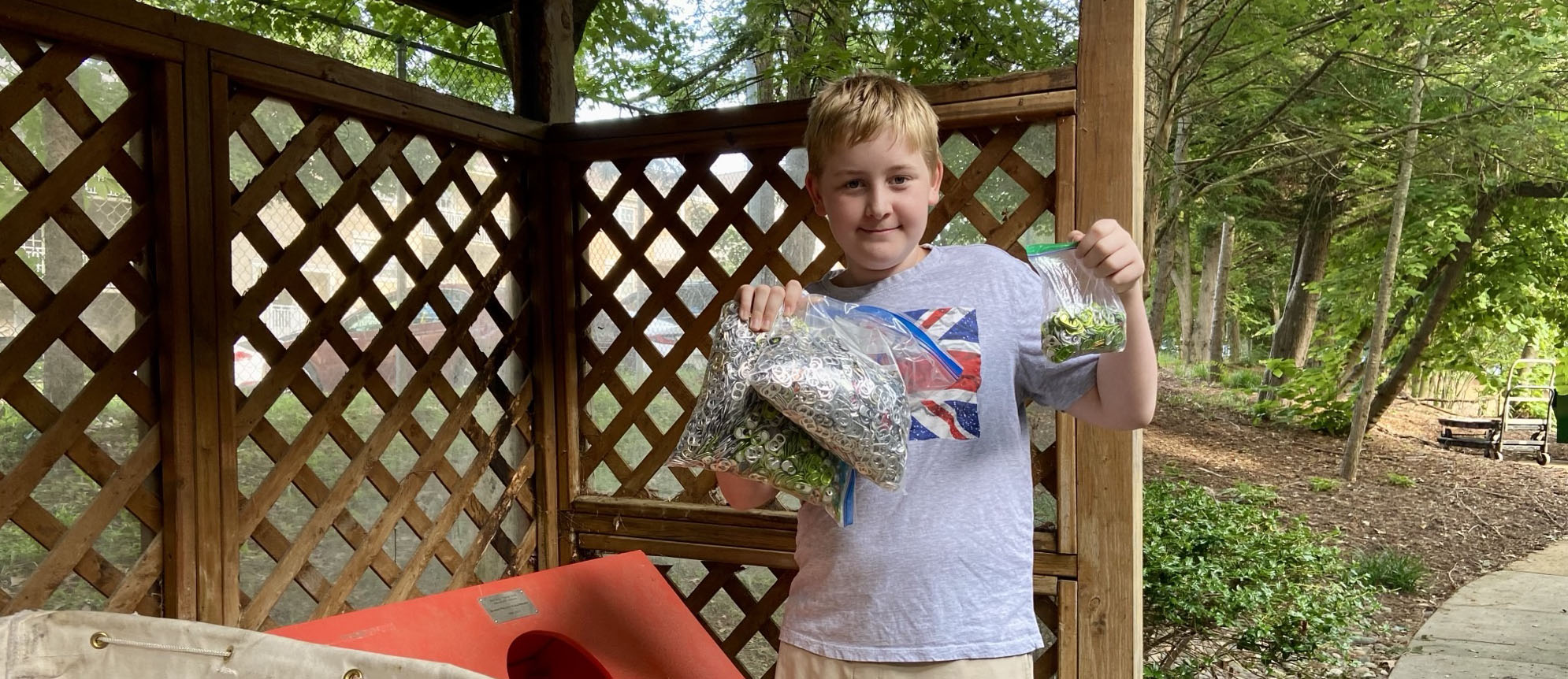 Desi poses with three bags of collected pop tabs after raising $312 through a school bake sale and donating the proceeds to Ronald McDonald House Washington DC.